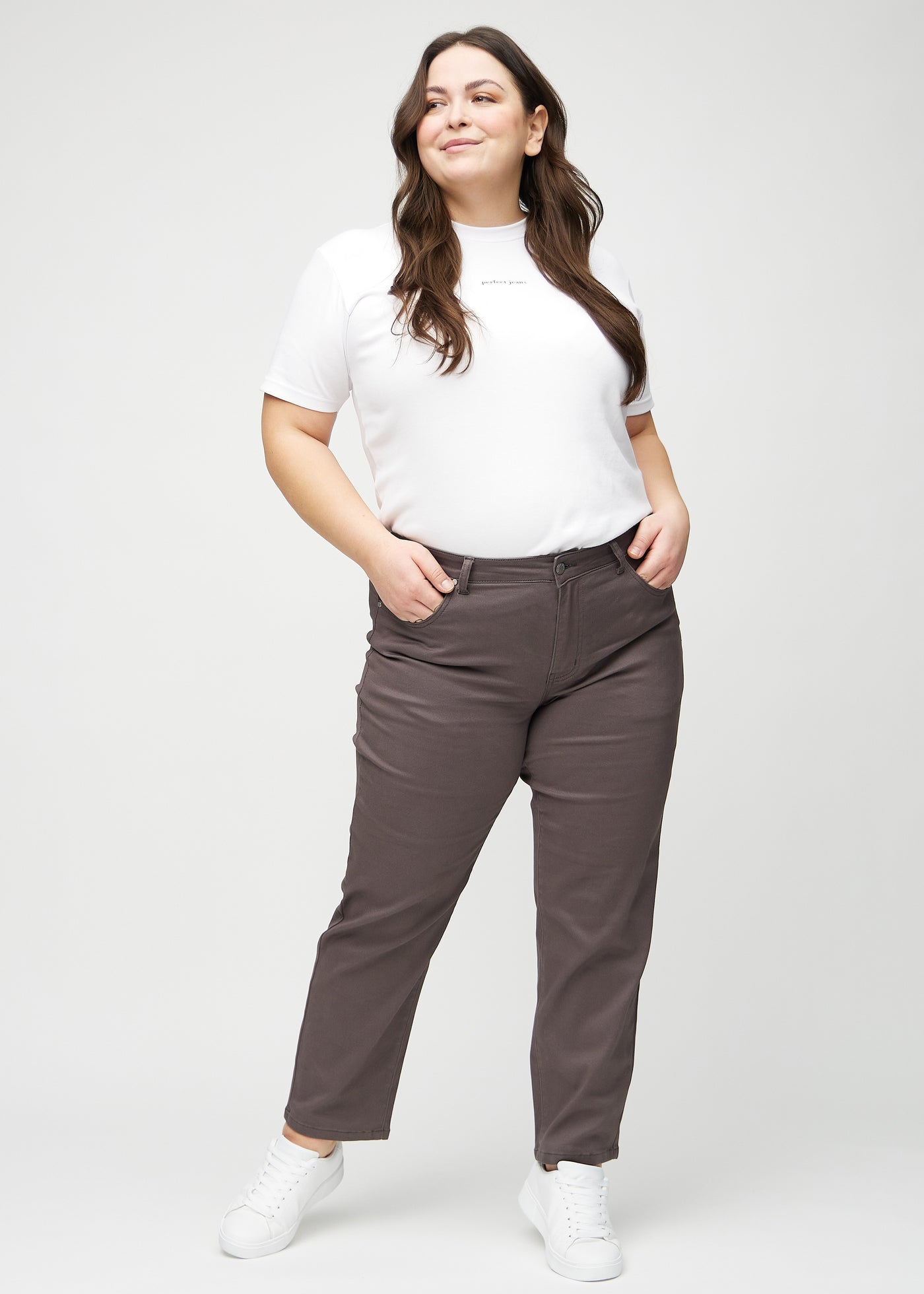 Fuldt billede af en plus-size model i gråbrune regular jeans.