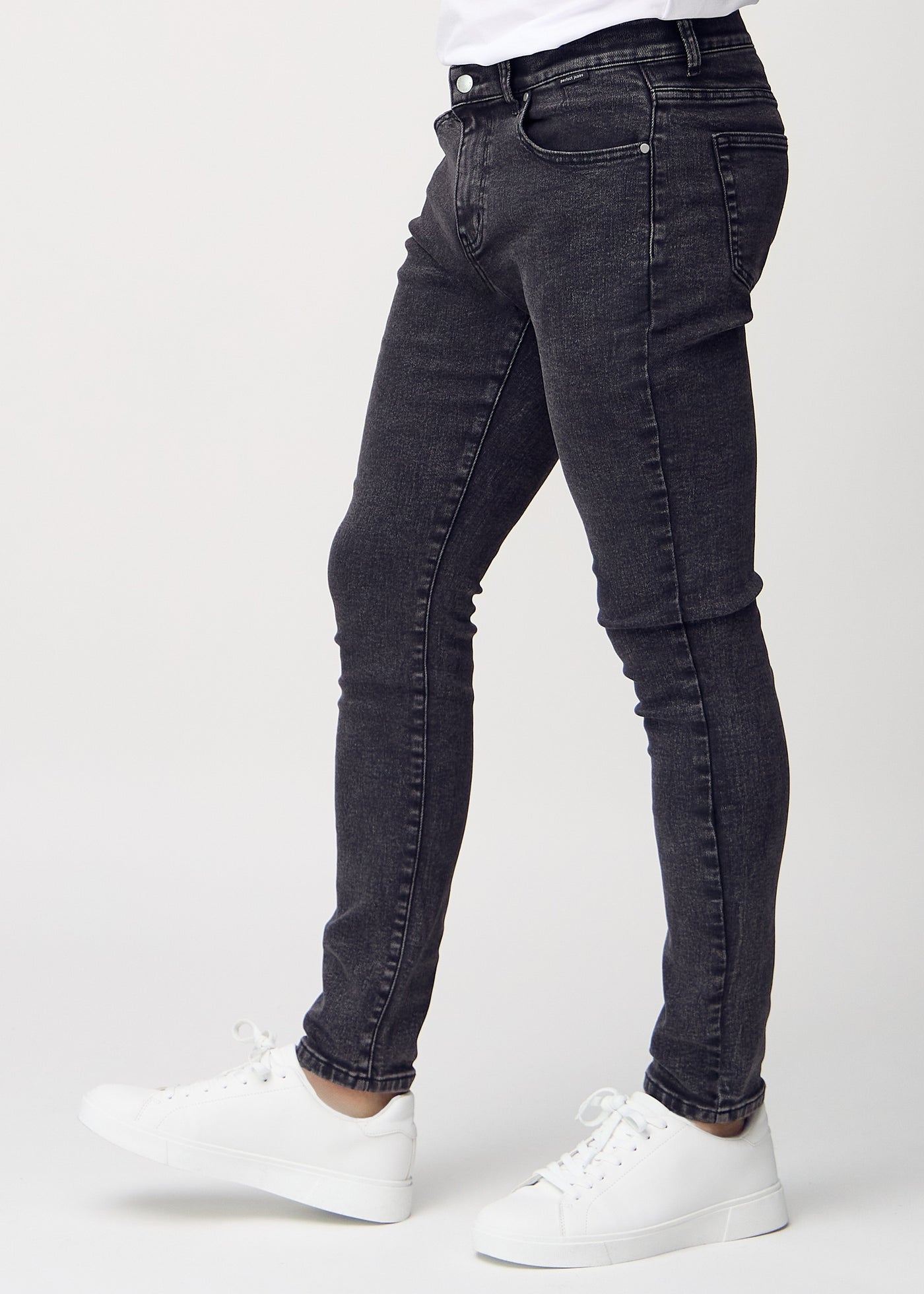 Mørkegrå denim slim jeans set fra siden på model.