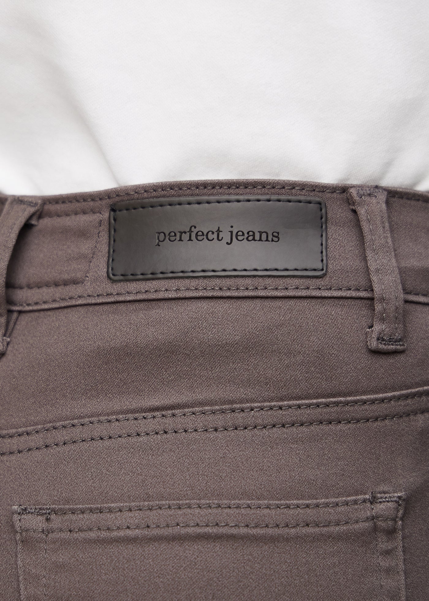 Baglommen på et par gråbrune jeans, hvor man kan se logoet.