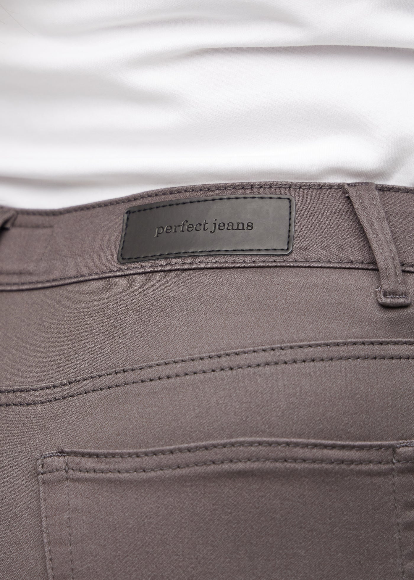 Baglommen på et par gråbrune jeans, hvor man kan se logoet på en plus-size model.